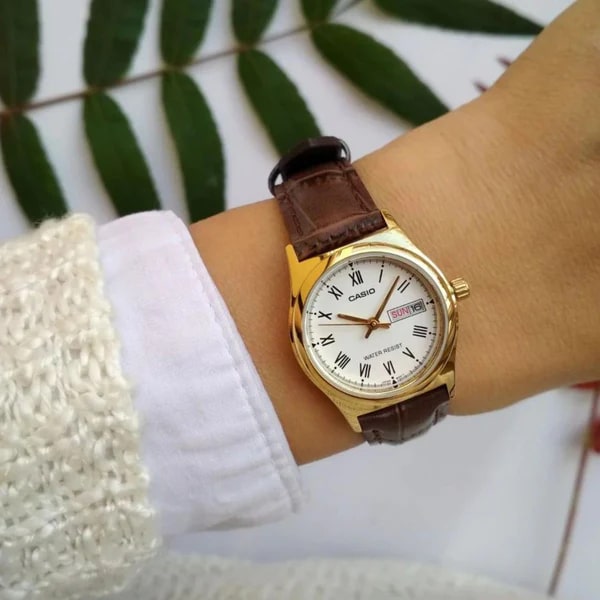 ساعة كاسيو نسائية بعلبة ذهبية وسوار جلد بني وواجهة بيضاء أنيقة