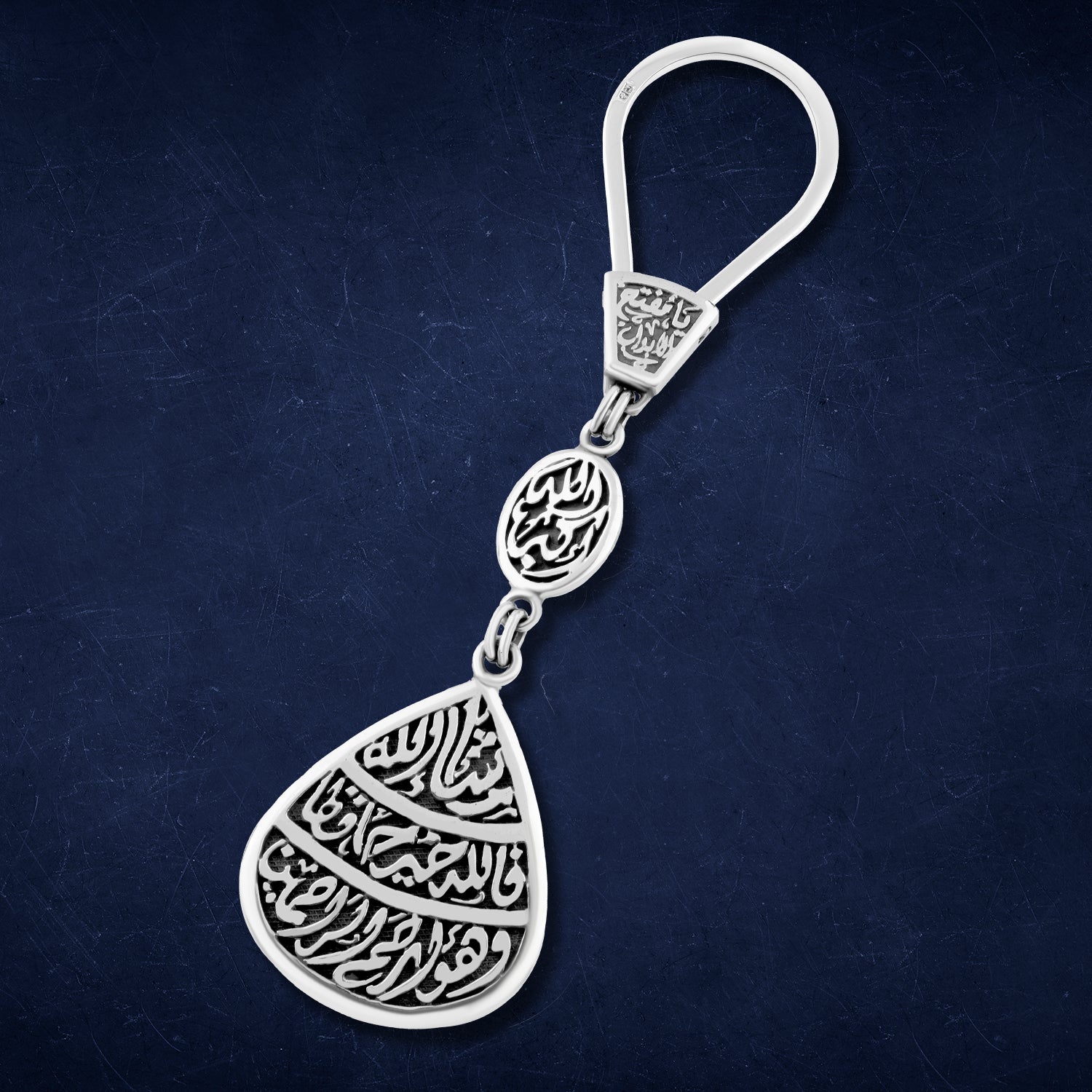 Silver teardrop-shaped keychain engraved with the words “For Allah is the Best Protector and He is the Most Merciful – Allahu Akbar – O Opener of Doors – Masha’Allah”