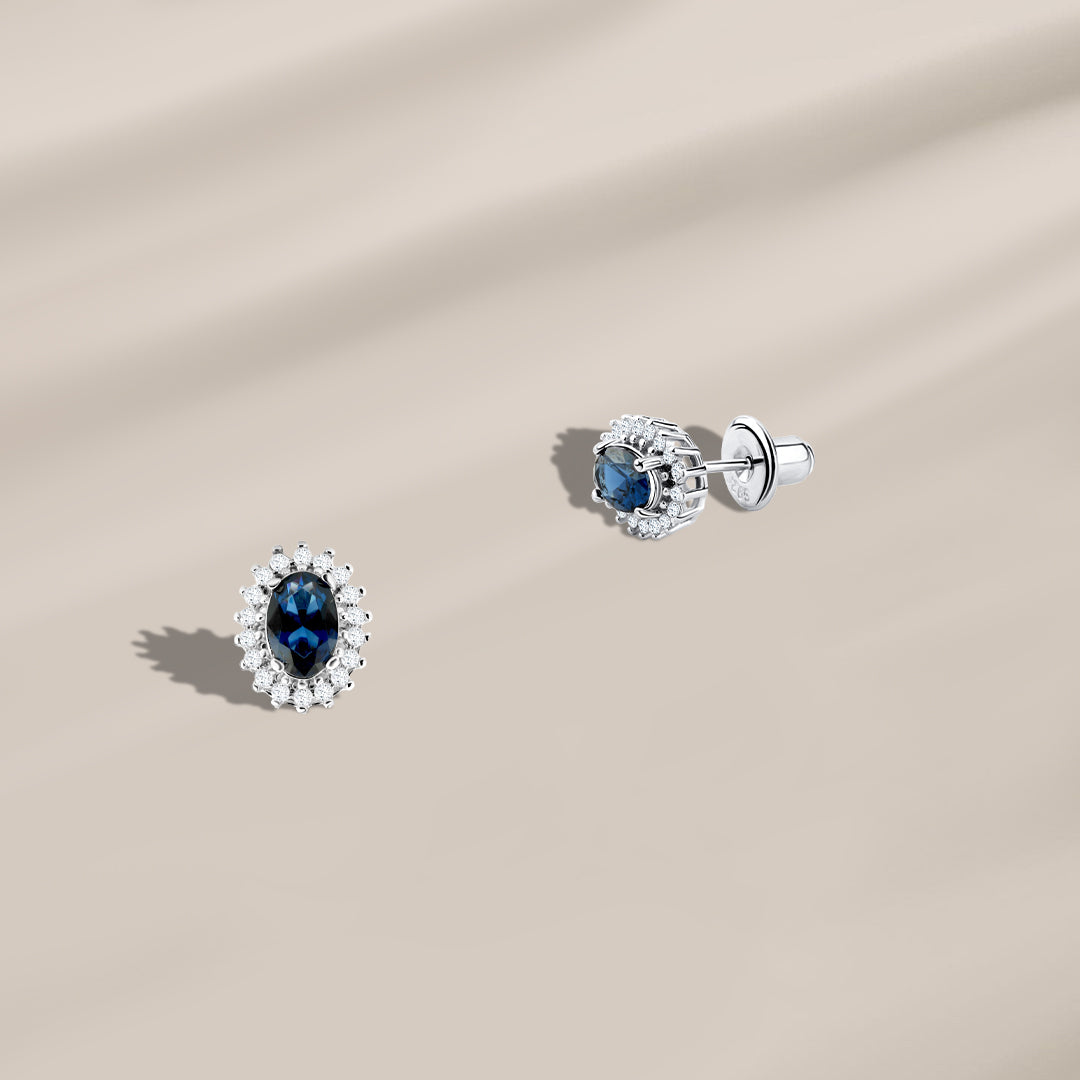 Spiral hoop earring with a round blue stone surrounded by 925 silver 
