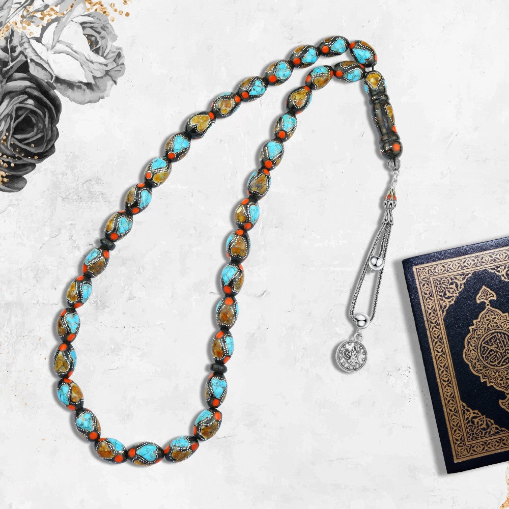 A rosary of natural jet, inlaid with silver, turquoise, and amber, 33 beads.
