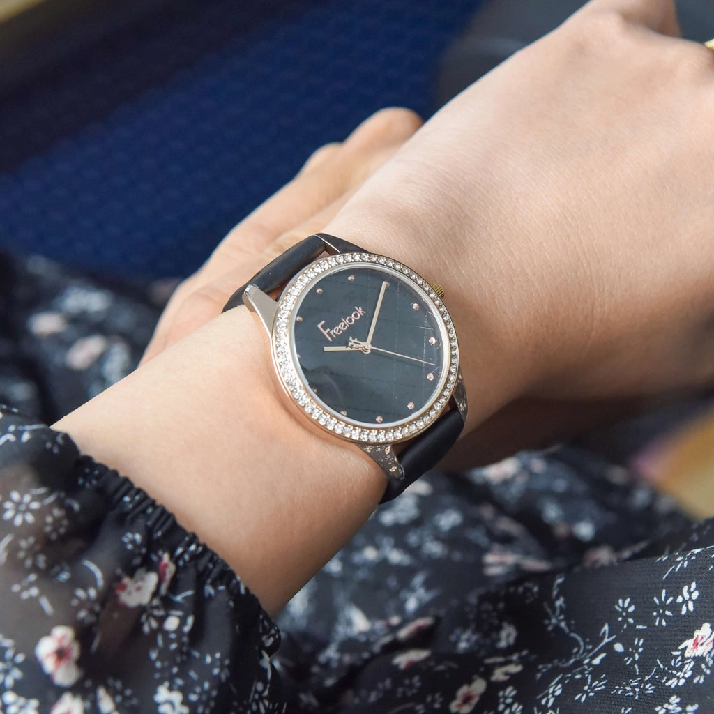 Freelook women's wristwatch with a rose gold case and black leather strap – delicate design with a crystal-studded bezel.
